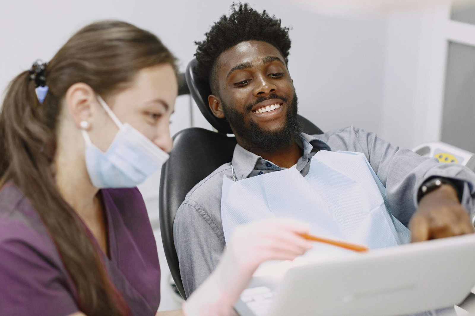 Smiling patient at the dentist's office, engaging with healthcare provider.